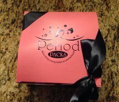 a pink box with black ribbon on it