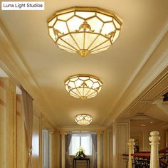 a long hallway with chandeliers and tables in the center is lit by two circular lights