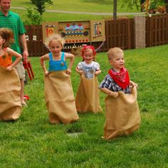 several children are playing in the yard with their parents and dads wearing paper bags