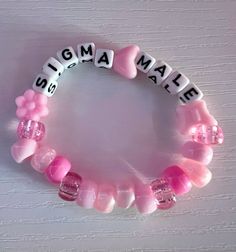 a pink and white bracelet with words made out of glass beads that spell the word mom