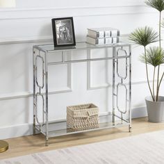 a silver metal console table with books and a basket on the floor next to it