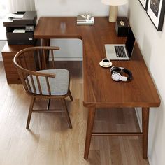 a laptop computer sitting on top of a wooden desk next to a chair and lamp