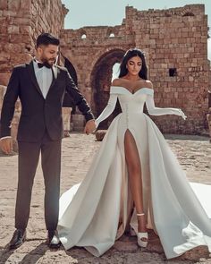 a man in a tuxedo and a woman in a wedding dress holding hands