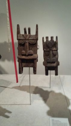 two wooden chairs sitting next to each other on display