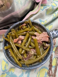 a bowl filled with green beans and meat