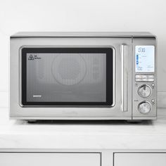 a silver microwave oven sitting on top of a counter