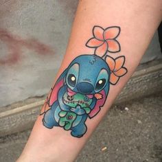 a small tattoo on the leg of a person's arm with stitching and flowers