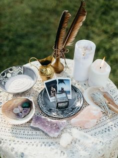 a table topped with pictures and candles on top of a white doily covered table