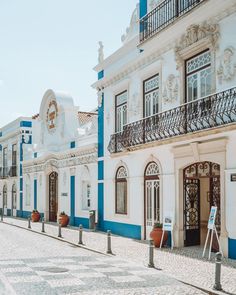 an empty street lined with white and blue buildings