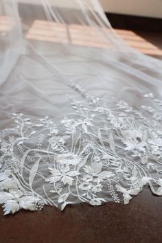 a white wedding dress is laying on the floor