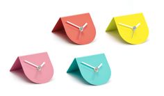 four different colored clocks with hands on them