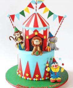 a circus themed birthday cake with animals and clowns on the top, in front of a white background