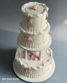 three tiered wedding cake with pink flowers on the top and white trimmings