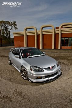 a silver car parked in front of a building