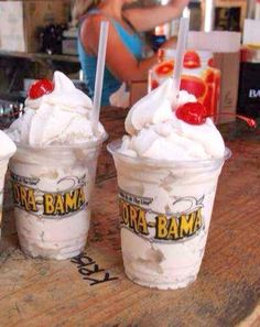 three ice cream sundaes sitting on top of a wooden table