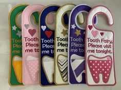 five toothbrush holders with different designs and words on them, lined up against a white wall