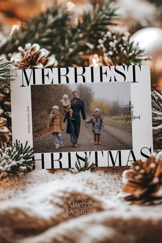 a christmas card with an image of two children walking down the road in front of pine cones