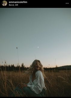 a woman sitting in the middle of a field