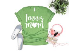 Tennis Mom Shirt Details: Sizes available are Adult S-XL These shirts are unisex and fit true to size. Size Recommendation: Use your normal T-shirt Size Shirts Colors offered for this design are Heather Maroon, Heather Black, Heather Navy, Deep Heather, Heather Olive, Heather Green, Heather Kelly, Heather Mustard, and Heather Sunset. Graphic colors available are White or Black Shirts are Bella + Canvas and are 100% Cotton Black Heather are 90/10 Cotton/Polyester Maroon Heather are 52/48 Cotton/Polyester When Should I expect my shirt? Once we receive your order, we will ship it out to you within 3-5 business days. Shipping time is also 3-4 days. Custom made Bella canvas T-shirt Care Instructions  *Wash in cold water inside out *Tumble dry low *Do not iron vinyl directly *When ironing place Green Relaxed Fit Shirt For Sports, Sports Shirt With Text Print In Relaxed Fit, Casual Sports Shirt With Name Print, Tennis Mom, Sunset Graphic, Tennis Life, Tennis Shirt, Black Shirts, Team Mom