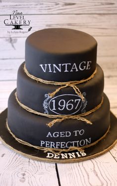 three tiered cake with the words vintage aged to perfection written on it and tied in twine