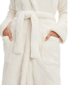 UGG 1121091 Cream Aarti Hooded Plush Robe Made of plush sherpa, the Aarti Robe offers a layer of cozy warmth for chilly mornings. Featuring front patch pockets and a self-belt, it pairs perfectly with loungewear essentials and your favorite slippers. PRODUCT DETAILS: 100% Polyester Hooded sherpa robe Self belt Front patch pockets Tonal UGG embroidery on pocket 36 3/8" Center Back Length [Size S] Ugg Scuffette, Fleece Robe, Soft Robes, Shawl Collar, Womens Uggs, Gowns Dresses, Sweater Dress, Lounge Wear, Slippers