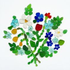 a bouquet of flowers made out of glass and sea glass beads on a white background