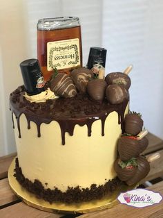 a chocolate covered cake sitting on top of a wooden table next to a jar of honey