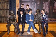 a group of young men sitting next to each other on top of a wooden bench