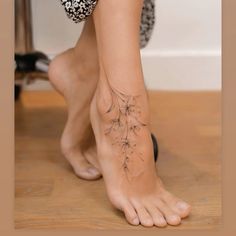 a woman's foot with a dandelion tattoo on her left ankle and right leg