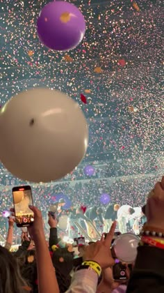 people are taking pictures with their cell phones while confetti is thrown in the air