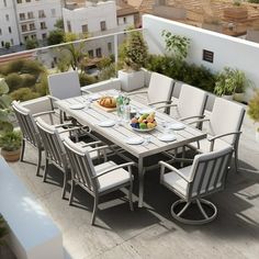 an outdoor dining table with white chairs and plates on it, overlooking a cityscape