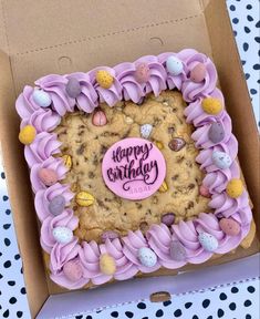 a birthday cake in a box decorated with pink icing