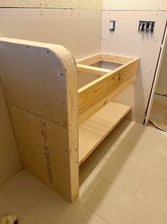 an unfinished wooden shelf in the corner of a room that is being built with plywood