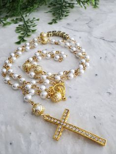 "Personalized rosary made with glass pearl beads, glory beads covered with gold plated bead caps, a Virgin Mary centerpiece, Rhinestone Cross, and acrylic cube letters It makes a great gift for First Communion, Baptism, Christening, Confirmation, Weddings, Graduation, etc  The name is ADDED to the 10 Hail Mary second section of the rosary  Cross size: 1 3/4\" Your rosary will be shipped to you in a bubble envelope Ready to ship in 1-2 business days The price includes the rosary with ONE name ONLY Total length of each rosary: around 20\" Bead size used: 6 & 8 mm Many thanks for stopping by and shopping . Please visit again soon and often so you don't miss any new listings! To see more of my work check out my  INSTAGRAM : Madewithbeads13" Cube Letters, Wedding Rosary, Rosary Cross, Personalized Rosary, The Rosary, Team Board, Rhinestone Cross, Hail Mary, Baptism Gifts