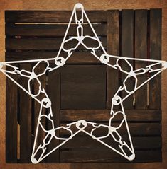 a white metal star hanging on a wooden wall