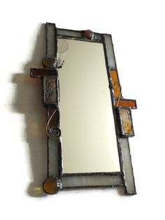 a mirror that is on the wall with some kind of decoration around it's edges