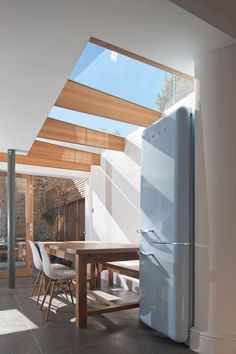 an image of a refrigerator in the middle of a room with skylights above it