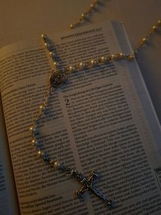 an open book with a rosary on it