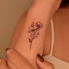 a woman's arm with a flower tattoo on the left side of her arm