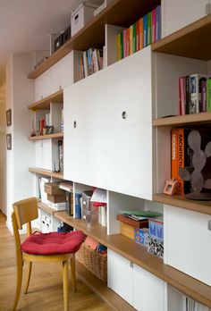 a room with some books on shelves and a chair