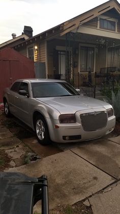 a silver car parked in front of a house