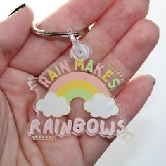 someone is holding a keychain that says rain makes rainbows in the sky