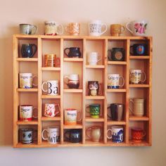 a wooden shelf filled with lots of coffee mugs