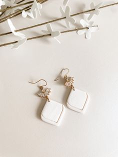 These handmade polymer clay earrings are designed to enhance the beauty of the bride on her special day.  The ear wire is 14k gold filled and hypoallergenic. The cubic zirconia fan attachment adds a touch of brilliance and elegance.  They are also comfortable to wear as they are lightweight.  These earrings are thoughtfully crafted to complement various bridal styles, whether it be a classic, modern, or bohemian look. With their classic design and attention to detail, these bridal earrings make Elegant Clay Earrings As A Gift, Elegant Clay Earrings For Gifts, Elegant Clay Drop Earrings, White Polymer Clay Earrings With Ear Wire, White Clay Earrings For Gift, White Clay Earrings As Gift, White Clay Earrings For Gifts, Elegant Handmade Clay Jewelry, White Clay Jewelry As A Gift