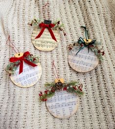 four christmas ornaments with sheet music on them