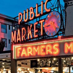 a sign that says farmers market in front of a building with a clock on it