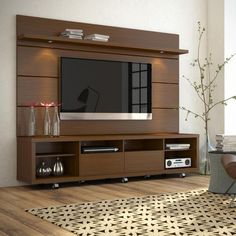 a living room with a large tv mounted on the wall and wooden furniture in front of it