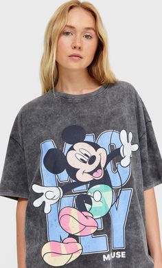 a woman wearing a mickey mouse t - shirt