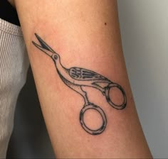 a tattoo on the arm of a woman with scissors