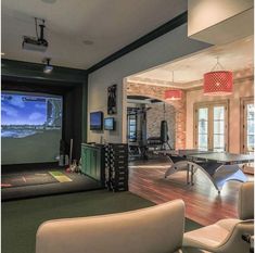 a living room filled with furniture and a flat screen tv mounted to the side of a wall